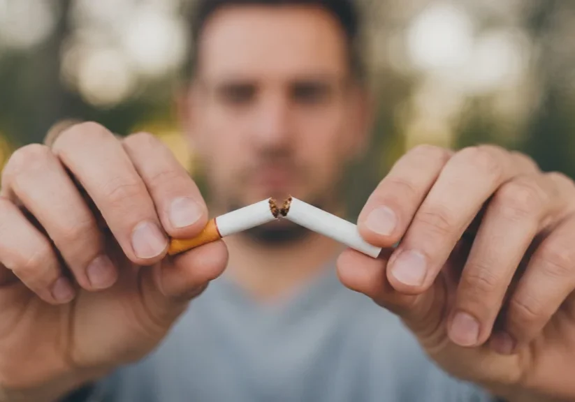 Photograph of a man breaking a cigarette in two